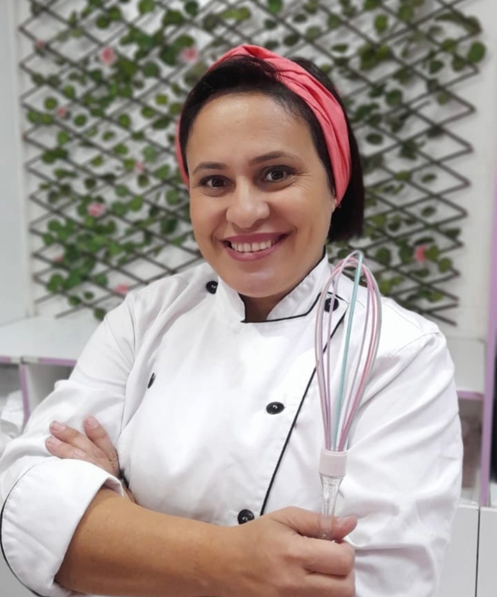 Patricia Gularte, fundadora e confeiteira da Sonho Encantado, sorrindo com um fouê nas mãos